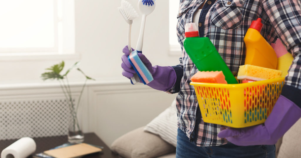 Woman with cleaning equipment ready to clean room