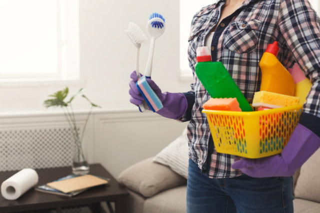 Woman with cleaning equipment ready to clean room